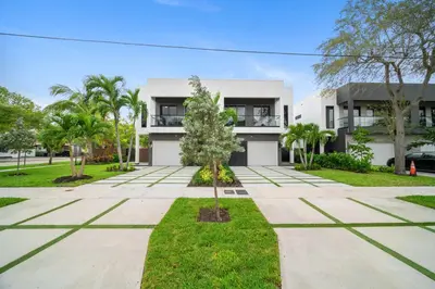a white house with trees in front of it at The Elements Luxury Home Fort Lauderdale in Fort Lauderdale