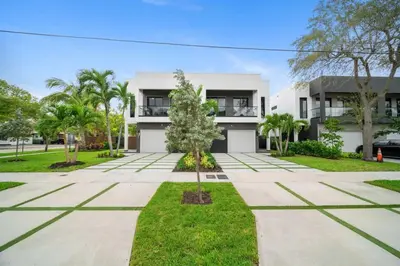 a white house with trees in front of it at The Elements Luxury Home Fort Lauderdale in Fort Lauderdale