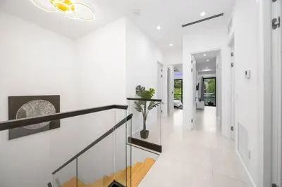 a white staircase in a house with a glass railing at The Elements Luxury Home Fort Lauderdale in Fort Lauderdale