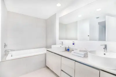 a white bathroom with two sinks and a mirror at Beachwalk Resort - Waterfront huge 3-Bedroom apartment with direct ocean-view! in Hallandale Beach