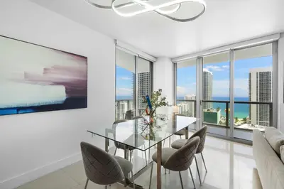 a dining room with a glass table and chairs at BeachWalk Resort - VIP TOWER - OCEANVIEW UNIT 3 BEDROOM & 3 BATHROOM in Hallandale Beach