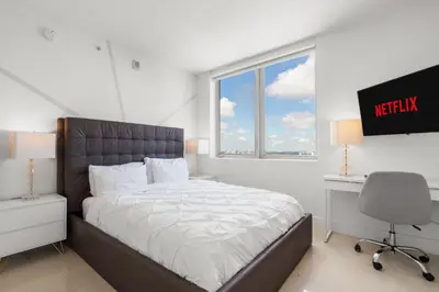 a bedroom with a bed and a desk and a television at BeachWalk Resort - VIP TOWER - OCEANVIEW UNIT 3 BEDROOM & 3 BATHROOM in Hallandale Beach