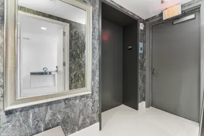 a mirror on a wall next to a bathroom at BeachWalk Resort - VIP TOWER - OCEANVIEW UNIT 3 BEDROOM & 3 BATHROOM in Hallandale Beach
