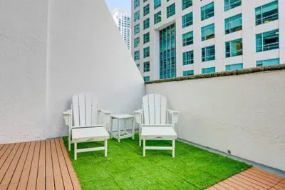 two white chairs and a table on a balcony at Best of Brickell's Luxury Suite with Pool and Gym in Miami