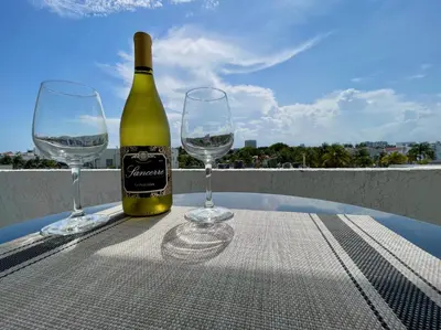 a bottle of wine and two wine glasses on a table at Large 1 bedroom apartment with free private parking in Miami Beach