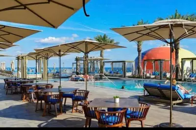 a pool with tables and chairs and umbrellas at Amazing apartment - Lyfe Resort & Resident in Hollywood