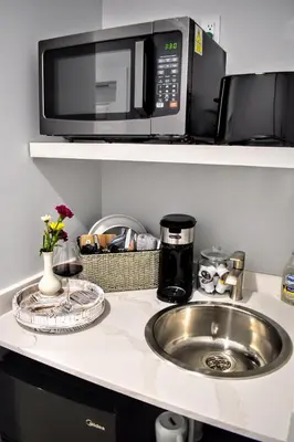 a kitchen counter with a sink and a microwave at Casa la Miami - Central location Villa with Pool & Gym in Miami