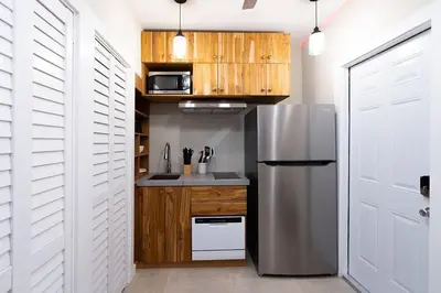 a kitchen with a stainless steel refrigerator and wooden cabinets at Elegant Miami Apartment East Little Havana / Free Parking in Miami