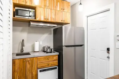 a small kitchen with a refrigerator and a microwave at Elegant Miami Apartment East Little Havana / Free Parking in Miami