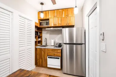 a kitchen with a stainless steel refrigerator and wooden cabinets at Elegant Miami Apartment East Little Havana / Free Parking in Miami