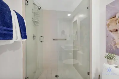 a white bathroom with a shower and a sink at Amazing Pool - Gym - Complementary Shuttle in Hallandale Beach