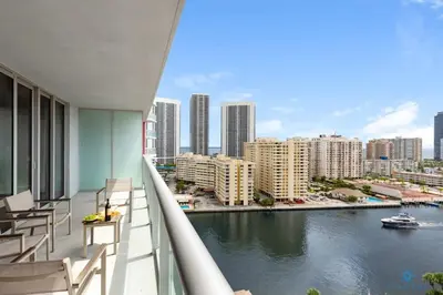 a balcony with chairs and a view of a river at Infinite View, Balcony with Gym and Amazing Pool in Hallandale Beach