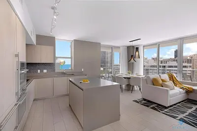 a kitchen and living room with a couch and a table at Wrap Around Balcony, Insane Amenities, Amazing Pool in Hollywood