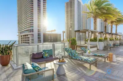 a balcony with chairs and palm trees on a building at Wrap Around Balcony, Insane Amenities, Amazing Pool in Hollywood