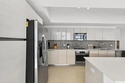 a kitchen with white cabinets and stainless steel appliances at Spacious VIP Penthouse with Ocean & Intracoastal Views, Private Entry, Resort Amenities in Hallandale Beach