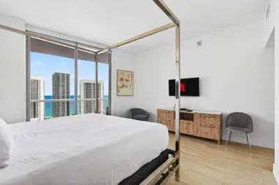 a bedroom with a large bed and a large window at Spacious VIP Penthouse with Ocean & Intracoastal Views, Private Entry, Resort Amenities in Hallandale Beach