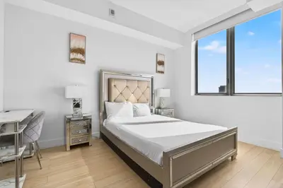 a bedroom with a bed and a desk and a window at Spacious VIP Penthouse with Ocean & Intracoastal Views, Private Entry, Resort Amenities in Hallandale Beach