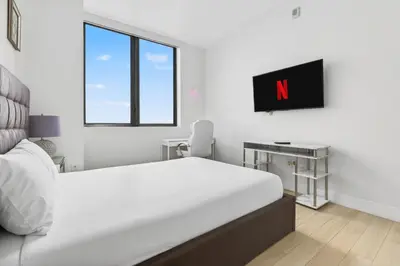 a white bedroom with a large bed and a desk at Spacious VIP Penthouse with Ocean & Intracoastal Views, Private Entry, Resort Amenities in Hallandale Beach
