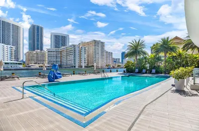 a swimming pool with a city skyline in the background at Spacious VIP Penthouse with Ocean & Intracoastal Views, Private Entry, Resort Amenities in Hallandale Beach