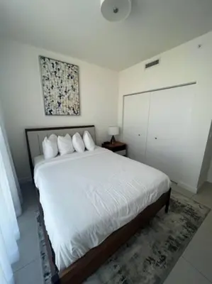 a bedroom with a bed with white sheets and pillows at APARTMENT FOR RENT 2 BED 2 BATH 1 Parking DOWNTOWN DORAL in Miami