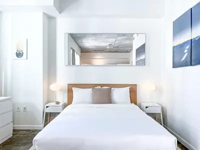 a bedroom with a white bed and a mirror above it at Center Stage- Downtown Parking Pool Hot Tub in Miami