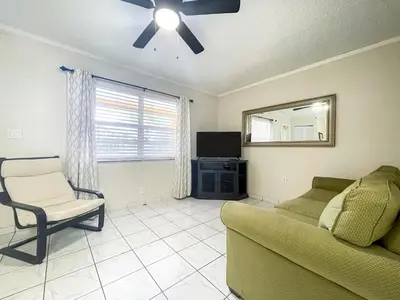 a living room with a couch and a ceiling fan at Hollywood by the Sea in Hollywood