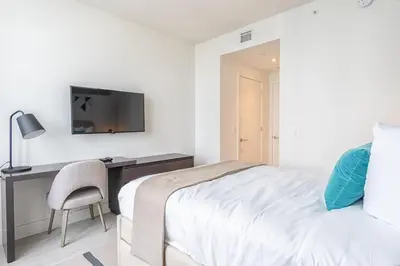 a bedroom with a bed and a desk with a television at Hyde Beach House 2309 in Hollywood