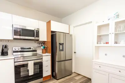 a kitchen with white cabinets and a stainless steel refrigerator at Marina Bay 406 in Miami Beach