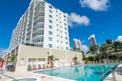 a hotel with a swimming pool in front of a building at Marina Bay 406 in Miami Beach