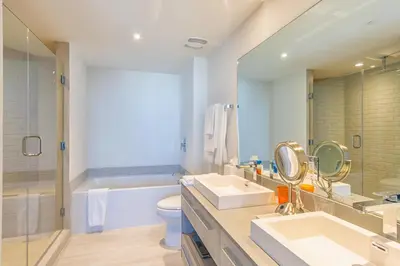 a bathroom with two sinks and a tub and a toilet at Hyde Beach House 2601 in Hollywood