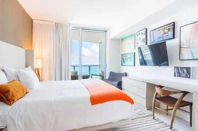 a hotel room with a bed and a desk and a window at Lyfe Beach Resort 3804 in Hollywood Beach