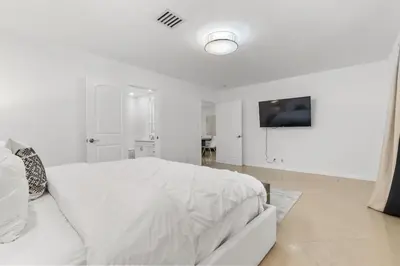 a white bedroom with a white bed and a tv at Spacious Modern Mansion w Pool & Sauna in Hollywood close to Beach in Hollywood