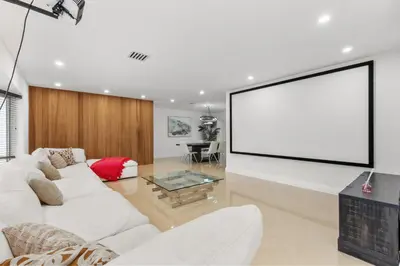 a living room with a white couch and a large screen at Spacious Modern Mansion w Pool & Sauna in Hollywood close to Beach in Hollywood
