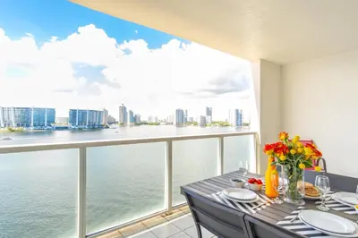 a dining room with a table and a view of the water at Marina Bay 1008 in Miami Beach