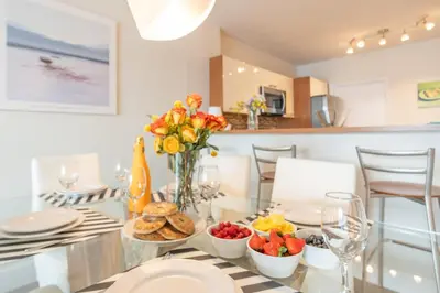 a dining room table with a vase of flowers and fruit at Marina Bay 1008 in Miami Beach