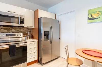 a kitchen with a stainless steel refrigerator and a table at Marina Bay 1008 in Miami Beach