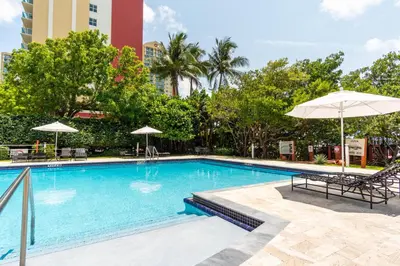 a swimming pool with chairs and umbrellas at a hotel at Golden Bay 703 in Miami Beach