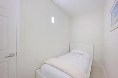 a small white room with a bed with white sheets at Ocean Reserve 1524 in Miami Beach