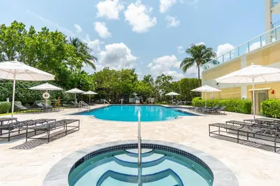 a pool at a hotel with chairs and umbrellas at Golden Bay 406 in Miami Beach