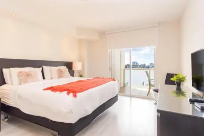 a bedroom with a large bed and a balcony at Golden Bay 408 in Miami Beach