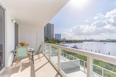 a balcony with a table and a view of the water at Golden Bay 408 in Miami Beach