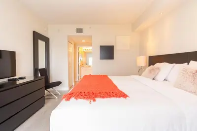 a bedroom with a large white bed and a television at Golden Bay 408 in Miami Beach