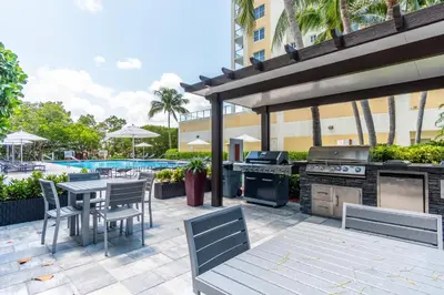 a patio with a grill and a table and chairs at Golden Bay 408 in Miami Beach