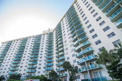 a large apartment building with palm trees in front of it at Ocean Reserve 927 in Miami Beach