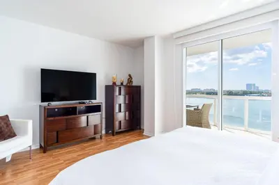 a bedroom with a bed and a flat screen tv at Golden Bay 805 in Miami Beach