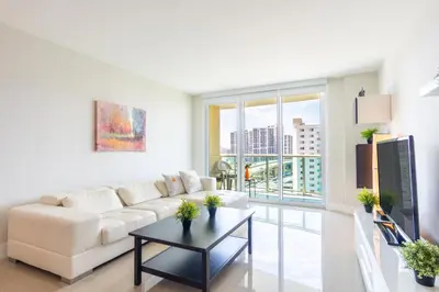 a living room with a white couch and a table at Ocean Reserve 1404 in Miami Beach