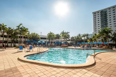 a swimming pool in a resort with palm trees and buildings at Ocean Reserve 1404 in Miami Beach