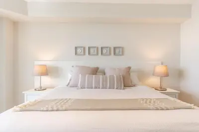 a white bedroom with a white bed with two lamps at Golden Bay 402 in Miami Beach