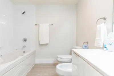 a white bathroom with a tub and a toilet and a sink at Golden Bay 402 in Miami Beach