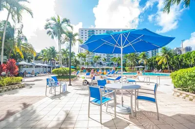 a table and chairs with an umbrella and a pool at Ocean Reserve 1508 in Miami Beach